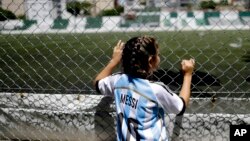 Twelve-year-old Candelabra Villegas wears a Lionel Messi's national team jersey, in Buenos Aires, Argentina. "Women are always recognized as less, and we are much more, we are stronger than them and we can achieve much more," said Villegas. (AP Photo/Nata