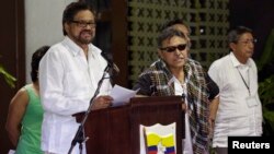 Revolutionary Armed Forces of Colombia (FARC) lead negotiator Ivan Marquez (L) reads from a document, next to fellow negotiator Jesus Santrich (C) during a conference in Havana, Cuba, Aug. 22, 2014. 