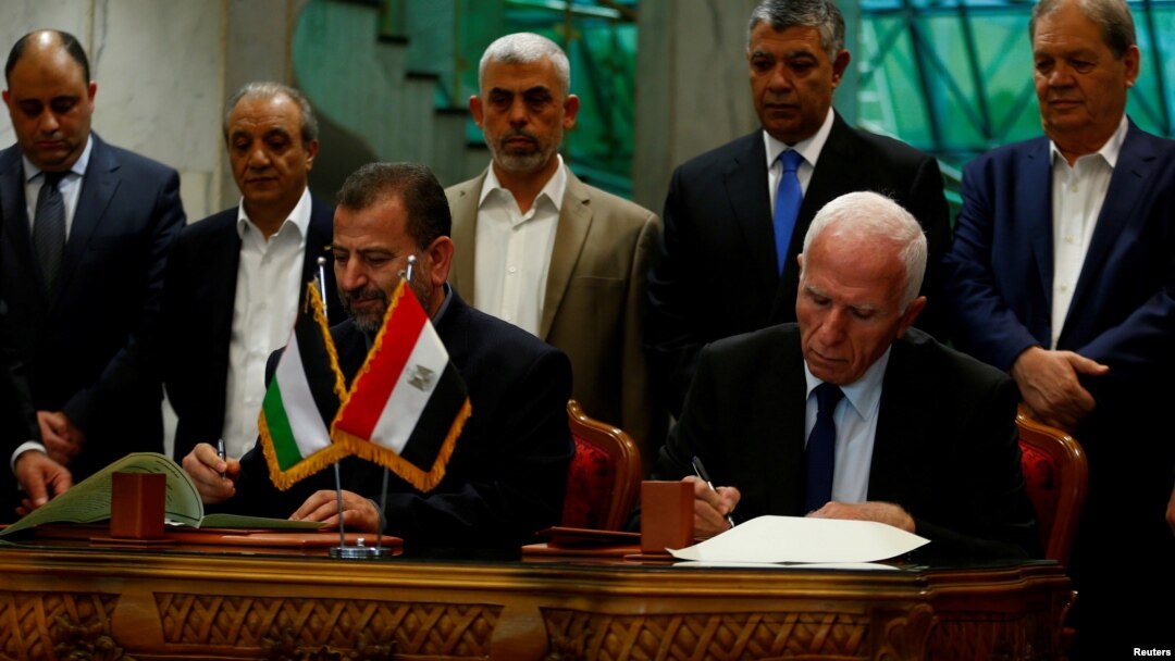 Ketua Delegasi Hamas Saleh Arouri dan Pemimpin Fatah Azzam Ahmad menandatangani kesepakatan rekonsiliasi di Kairo, Mesir, 12 Oktober 2017.