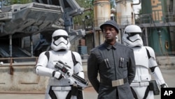 A First Order officer, center, and two storm troopers on patrol during a preview of the Star Wars-themed land, Galaxy's Edge in Hollywood Studios at Disney World, Aug. 27, 2019, in Lake Buena Vista, Florida.
