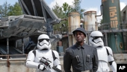 A First Order officer, center, and two storm troopers on patrol during a preview of the Star Wars-themed land, Galaxy's Edge in Hollywood Studios at Disney World, Aug. 27, 2019, in Lake Buena Vista, Florida.