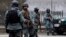 FILE - Afghan policemen stand at the site of a suicide attack in Kabul, February 26, 2015.