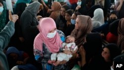 Women wait inside the passport office in Kabul, Afghanistan, June 30, 2021. Afghans are lining up by the thousands at the Afghan Passport office, uncertain what tomorrow will bring as they witness the final withdrawal of the U.S. military.