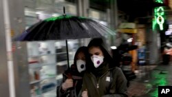 Pedestrians wear masks and gloves to help guard against the Coronavirus in downtown Tehran, Iran, Feb. 25, 2020.