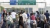 Travelers carry their luggage, as they walk towards the Beirut Rafik Hariri international airport after some of the families of 11 Lebanese pilgrims kidnapped in Syria blocked the highway leading to Beirut airport to protest the Lebanese government's fail