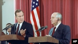 FILE - President George H.W. Bush gestures during a joint news conference with Soviet President Mikhail Gorbachev, at the Soviet Embassy in Madrid, Oct. 29, 1991. Bush died at the age of 94 on Friday, Nov. 30, 2018.