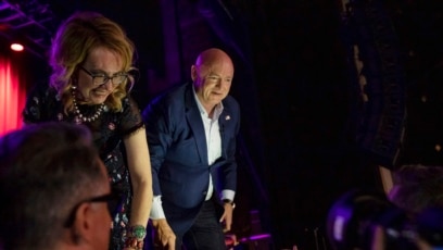 El senador Mark Kelly con su esposa, la exrepresentante Gabrielle Giffords, saludan a simpatizantes en Tucson, Arizona, el 8 de noviembre de 2022.