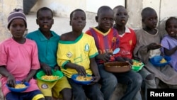 FILE - Children displaced as a result of Boko Haram attacks in the northeast region of Nigeria, eat at a camp for internally displaced persons (IDP) in Yola, Adamawa State, Jan. 13, 2015. 