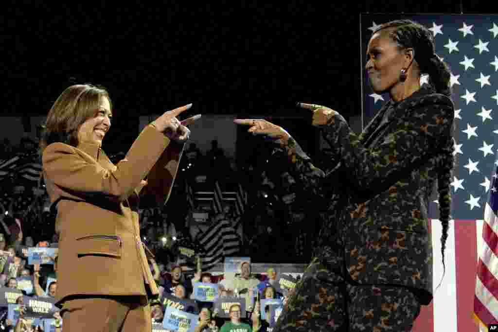 Democratic presidential nominee Vice President Kamala Harris, left, and former first lady Michelle Obama arrive to speak during a campaign rally at the Wings Event Center in Kalamazoo, Michigan, Oct. 26, 2024.