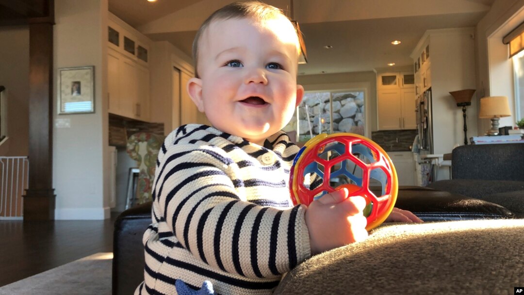 Archivo - Mason Camas, sonríe a su madre, Jocelyn Smith, quien cuida a su hijo de 11 meses en su casa en Camas, Washington, el 30 de enero de 2019, ante el temor del brote de sarampión en el suroeste del estado.