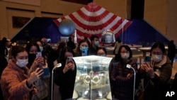 Visitors to the National Museum look at a display of the lunar rock samples retrieved from the moon by China's Chang'e 5 lunar lander late last year in Beijing, March 12, 2021.