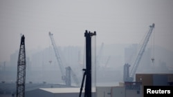 FILE - Cranes are seen on a polluted day in Incheon, South Korea, May 30, 2016. 