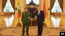 El jefe militar de Birmania, y ahora líder del país, el general Min Aung Hlaing, a la izquierda, y el ministro de Exteriores chino Wang Yi, posan para una foto durante su reunión el 12 de enero de 2021.