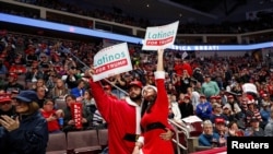 Foto de Archivo. Una pareja sostiene un rótulo con la frase "Latinos por Trump", durante un mítin de campaña donde participó el presidente Trump en Pensilvania.