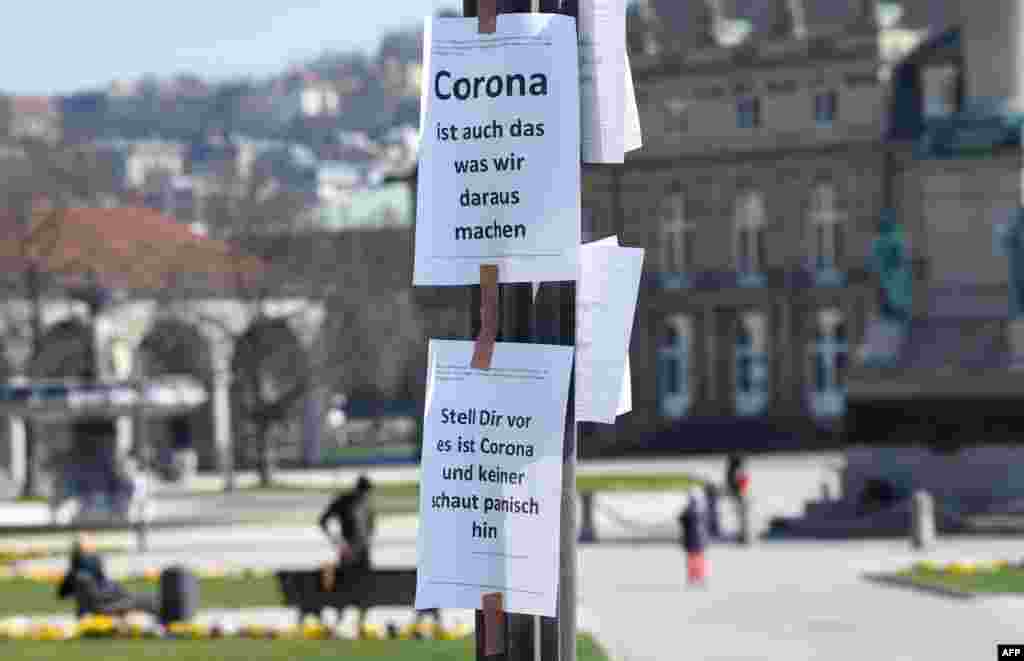 Signs reading &quot;Corona is also what we do out of it&quot; (top), and &quot;Imagine this is Corona and nobody looks at it in panic&quot; are seen on a pole in Stuttgart, Germany.