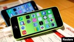 FILE - These then-new Apple iPhone 5c models were on display in at Tokyo store on Sept. 20, 2013. A 5c is at the center of Apple's battle with the FBI over efforts to break the company's proprietary auto-destruct security system. 