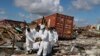 A Bahamas coroners team carries a body out of The Mudd neighborhood in the Marsh Harbor area of Abaco Island in the Bahamas in the aftermath of Hurricane Dorian, Sept. 9, 2019. 