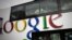 FILE - Passengers look through windows on a bus painted with an advertisement for Google in Beijing, China.