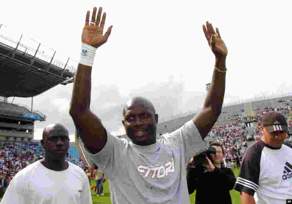 L&#39;ancien footballeur libérien George Weah , à droite, salue la foule au cours du match de son jubilé joué à Marseille, au Sud de la France, samedi 11 juin 2005. Weah a annoncé sa candidat aux prochaines élections pour le Sénat après au Liberia.