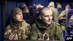 This grab taken from a handout footage released by the Russian Defence Ministry on January 3, 2024 shows Russian prisoners of war (POWs) inside a bus at the Russian-Ukrainian state border in the Belgorod region following a swap.