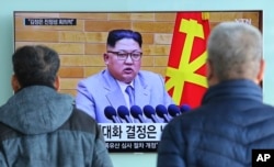 FILE - People watch a TV screen showing North Korean leader Kim Jong Un's New Year's speech, at Seoul Railway Station in Seoul, South Korea, Jan. 3, 2018. North and South Korea agreed Friday to revive their formal dialogue.