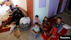 Civilians who fled their homes due to the clashes on the outskirts of Falluja, gather in the town of Garma, Iraq, May 30, 2016. 