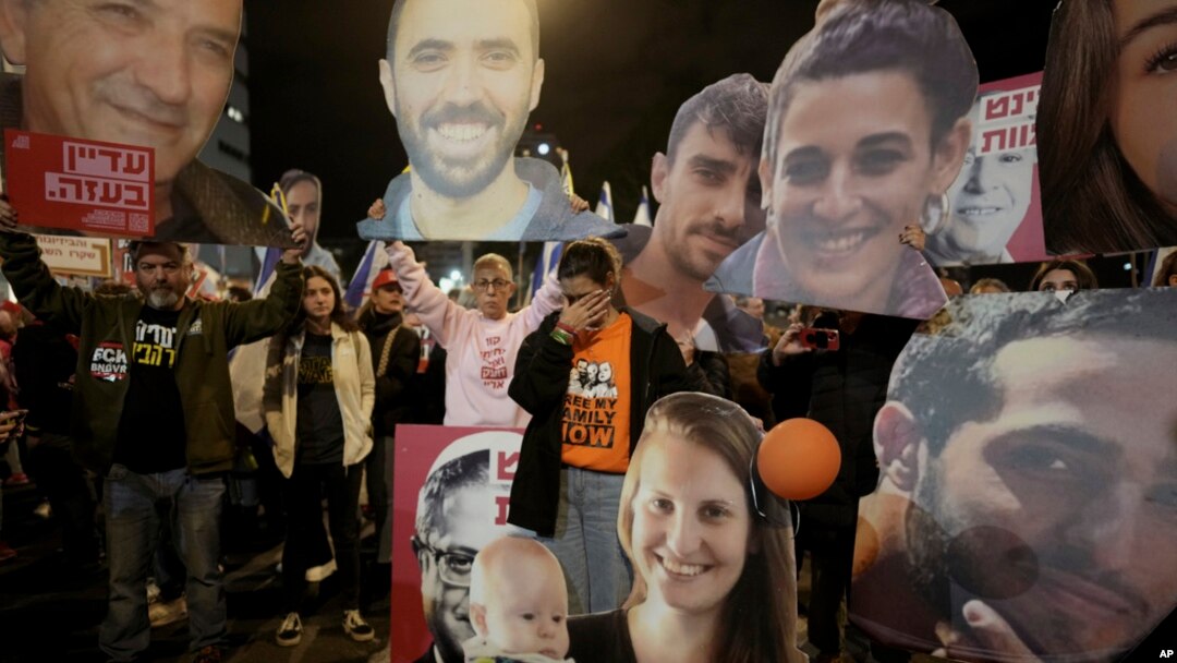 Demonstranti drže portrete talaca koje Hamas drži u Pojasu Gaze tokom protesta koji pozivaju na njihovo hitno oslobađanje u Tel Avivu, Izrael, 18. januara 2025.