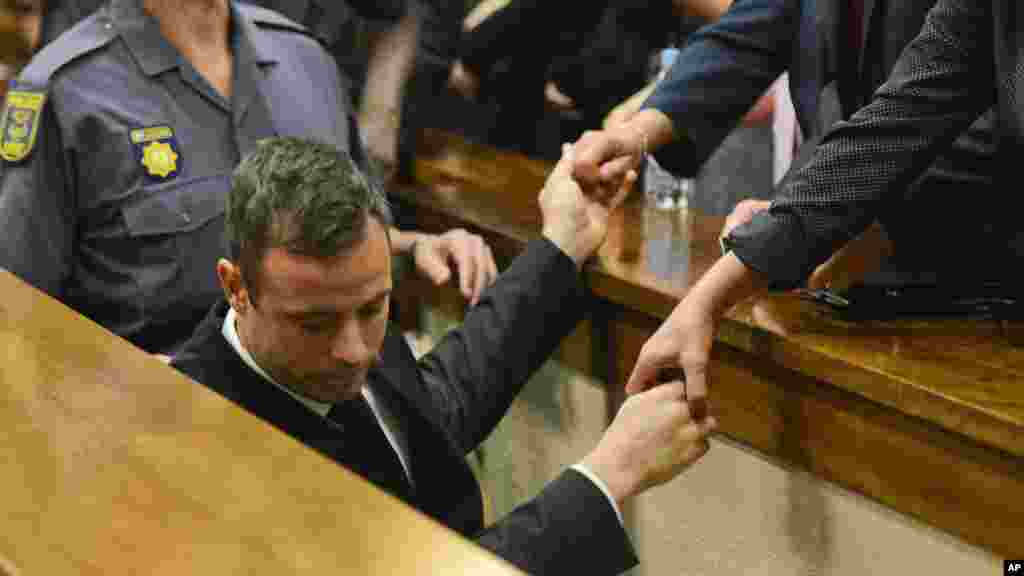 Juste après le verdict, Oscar Pistorius est conduit immédiatement vers les cellules souteraines de la cour à Pretoria. Sa famille a juste le temps de serrer ses mains un bref instant. Le 21 octobre 2014. 