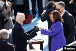 លោក Joe Biden និងអ្នកស្រី Kamala Harris ទល់ដៃគ្នាក្នុងកាយវិការស្វាគមន៍គ្នាទៅវិញទៅមក មុនធ្វើសច្ចាប្រណិធានចូលកាន់តំណែង នៅវិមានសភាសហរដ្ឋអាមេរិក ក្នុងរដ្ឋធានីវ៉ាស៊ីនតោន ថ្ងៃពុធ​ ទី២០ ខែមករា ឆ្នាំ២០២១។