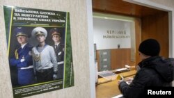 A man stands in front of a counter's window at a district army recruiting office in Kyiv, Ukraine, March 2, 2014.