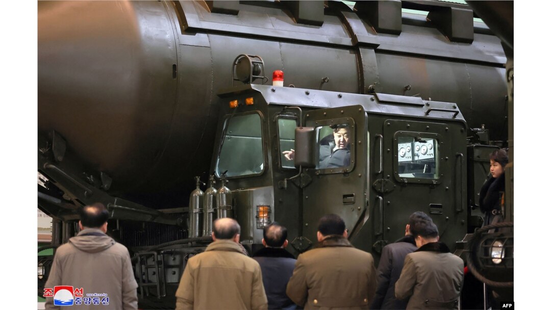 Pemimpin Korea Utara Kim Jong Un (tengah atas) menaiki peluncur transportasi saat ia memeriksa pabrik produksi kendaraan militer penting bersama putrinya Ju Ae (jauh kanan) di lokasi yang dirahasiakan di Korea Utara. (Foto: KCNA VIA KNS/AFP)