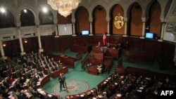 FILE - Tunisian Prime Minister Youssef Chahed addresses parliament during a session in Tunis, March 23, 2018.