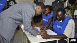 Burkina Faso incumbent President Blaise Compaore signs a document after casting his ballot at a polling station during legislative and municipal elections, in Ouagadougou, December 2, 2012.