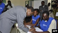 Le président Blaise Compaoré signe un document après son vote au scrutin du 2 déc. 2012, à Ouagadougou