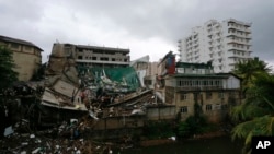 Sri Lankan military rescuers and firefighters search for trapped people in the debris of a five-story building under construction that collapsed in Colombo, Sri Lanka, May 18, 2017. The reason for the collapse was not immediately known. 