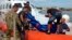 The body of a drowned migrant is being unloaded from a Coast Guard boat in the port of Lampedusa, Italy, Oct. 3, 2013. 