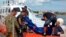 The body of a drowned migrant is being unloaded from a Coast Guard boat in the port of Lampedusa, Italy, Oct. 3, 2013. 