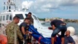 The body of a drowned migrant is being unloaded from a Coast Guard boat in the port of Lampedusa, Italy, Oct. 3, 2013. 