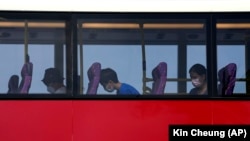 Penumpang tidurdi dek atas bus tingkat di Hong Kong, Sabtu, 16 Oktober 2021. Bagi warga yang merindukan kegiatan bepergian yang santai, sebuah agen perjalanan kini menawarkan solusinya, yakni Bus Tidur. (Foto: AP/Kin Cheung)