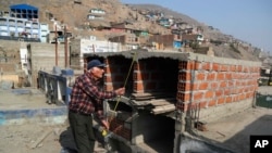 Retired merchant Victor Coba takes measurements of the tombs he's building for his family at San Lazaro cemetery on the outskirts of Lima, Peru, May 12, 2021. 