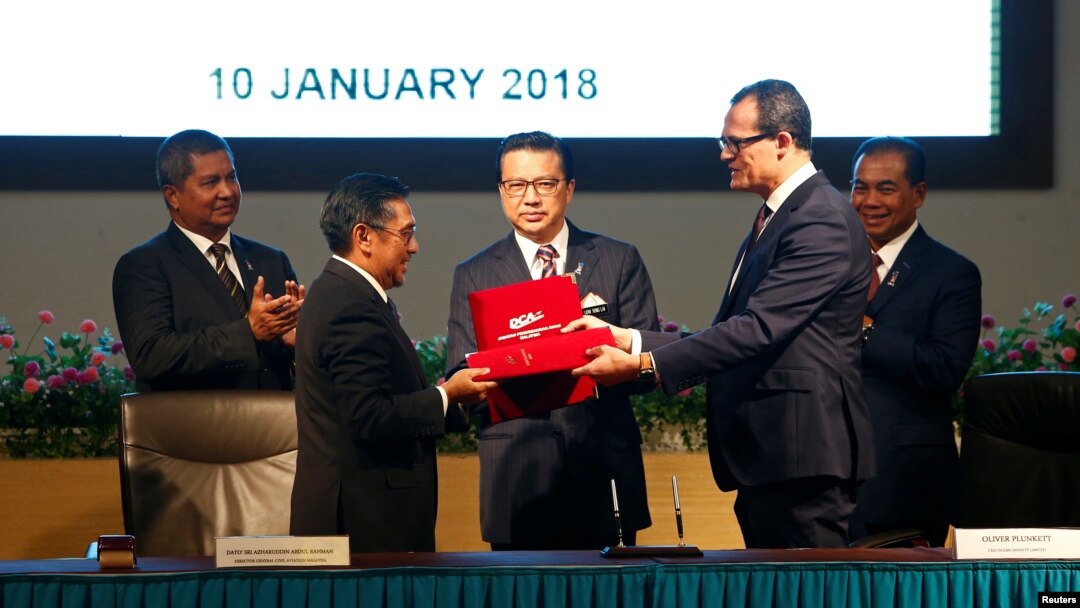 Tư liệu:Tổng Giám đốc Cơ quan Hàng không dân dụng Malaysia Azharuddin Abdul Rahman và CEO Ocean Infinity Oliver Plunkett trao đổi tài liệu trong lễ ký kết các hoạt động tìm kiếm máy bay MH370 tại Putrajaya, Malaysia, ngày10/1/2018. REUTERS/Lai Seng Sin 