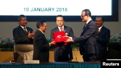 Direktur Jenderal Penerbangan Sipil Malaysia, Azharuddin Abdul Rahman dan CEO Ocean Infinity, Oliver Plunkett, saling bertukar dokumen seusai penandatanganan kesepakatan operasi pencarian pesawat MH370 antara pemerintah Malaysia dan Ocean Infinity, di Putrajaya, Malaysia, 10 Januari 2018. (Foto: dok).