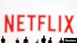 FILE PHOTO: Toy figures of people are seen in front of the displayed Netflix logo, in this illustration