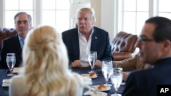 President Donald Trump, center, meets Treasury Secretary Steven Mnuchin, right, and Secretary of Veterans Affairs David Shulkin, left, along with other members of his cabinet and the White House staff at the Trump National Golf Club in Sterling, Va., Marc