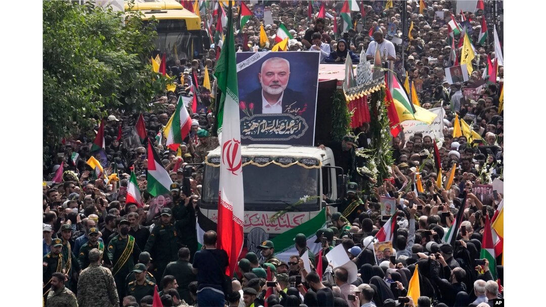 Warga Iran mengikuti truk, di tengah, yang membawa peti jenazah pemimpin Hamas Ismail Haniyeh di Enqelab-e-Eslami (Revolusi Islam) Sq. di Teheran, Iran, Kamis, 1 Agustus 2024. (Foto: AP)