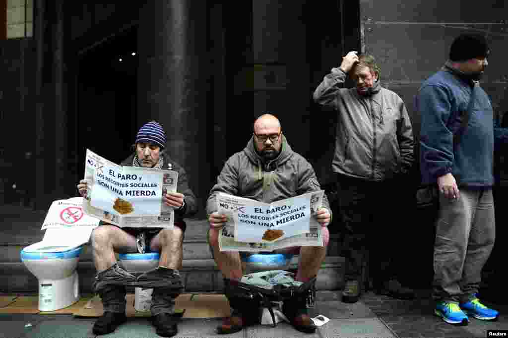 Protesters sit on lavatories outside the headquarters of the Basque Nationalist Party, Spain