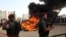 Hamas security forces stand guard while they burn some 1,383 bars of hashish and 1,242,000 pills of Tramadol, that have been seized since the beginning of the year, before they burn it, in Gaza City, Monday, Oct. 22, 2018. 