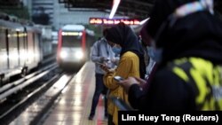 Para penumpang menggunakan masker menunggu kereta LRT (light rail transit) di sebuah stasiun di tengah pandemi COVID-19, di Kuala Lumpur, Malaysia, 1 Oktober 2020. (Foto: Lim Huey Teng/Reuters)