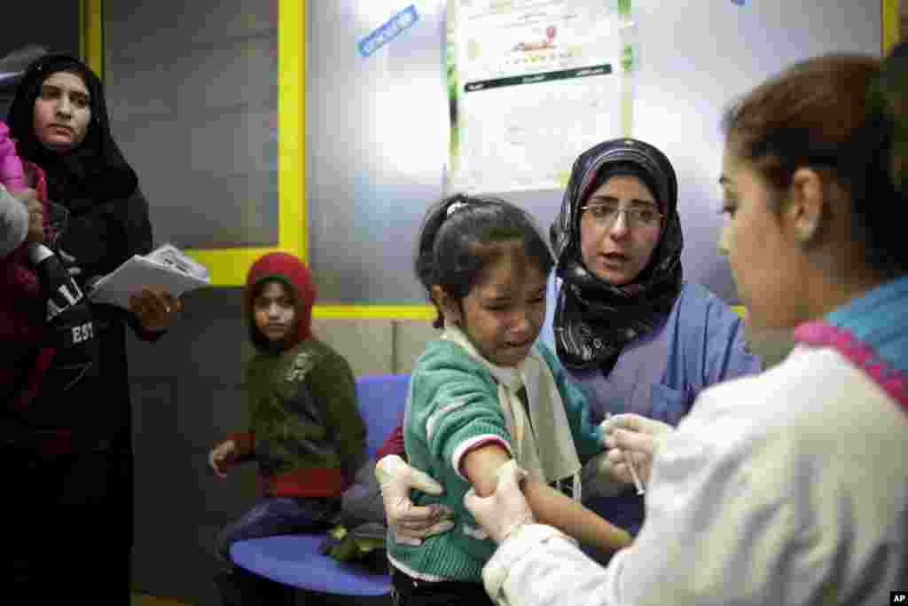 A Syrian girl weeps after receiving the measles vaccine from UNICEF nurses at the U.N. refugee agency&#39;s registration center in Zahleh, in Lebanon&#39;s Bekaa Valley.