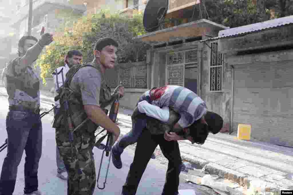 A member of the Free Syrian Army carries his wounded comrade who was shot during clashes with Syrian Army forces as others shout for help in Aleppo, Syria, September 27, 2012.